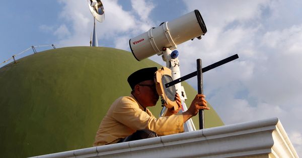 Foto: Un musulmán observa en qué fase se encuentra la luna desde una mezquita de Yakarta. (Reuters)