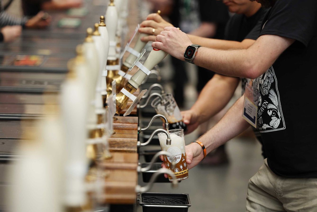 Personas se sirven cerveza en el Great British Beer Festival en Londres, Gran Bretaña. (EFE/NEIL HALL)