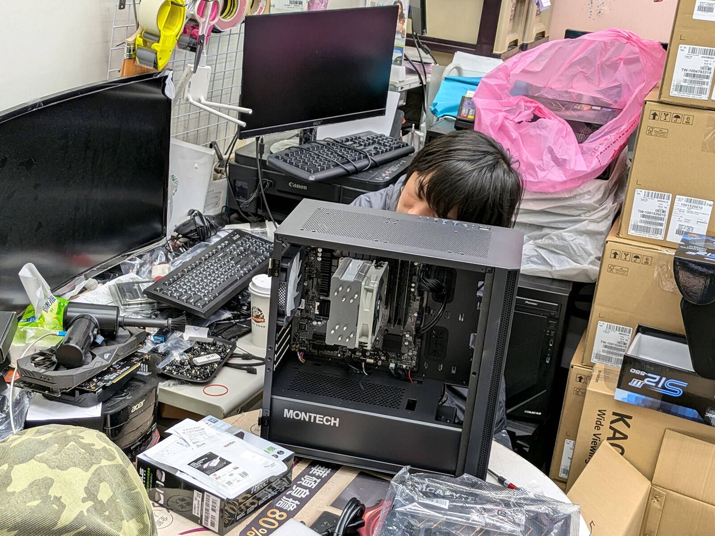 Un empleado repara un ordenador de mesa en una tienda del mercado de electrónica Guanghua Digital Plaza, en Taipéi. (Albert Sanchis)