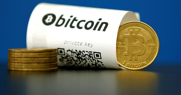 Foto: Monedas 'bitcoin' junto a un tique con código QR. (Reuters)