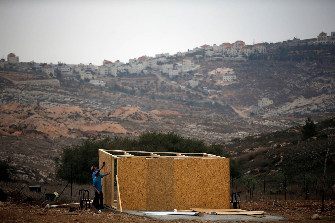 Jóvenes israelíes construyen una estructura de madera en la colonia de Amona, Cisjordania, el 29 de noviembre de 2016 (Reuters). 
