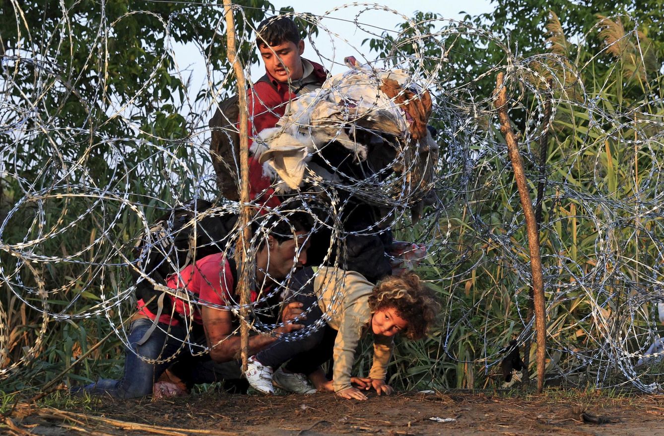 Refugiados sirios cruzan una alambrada para entrar en Hungría, cerca de Roszke (Reuters).