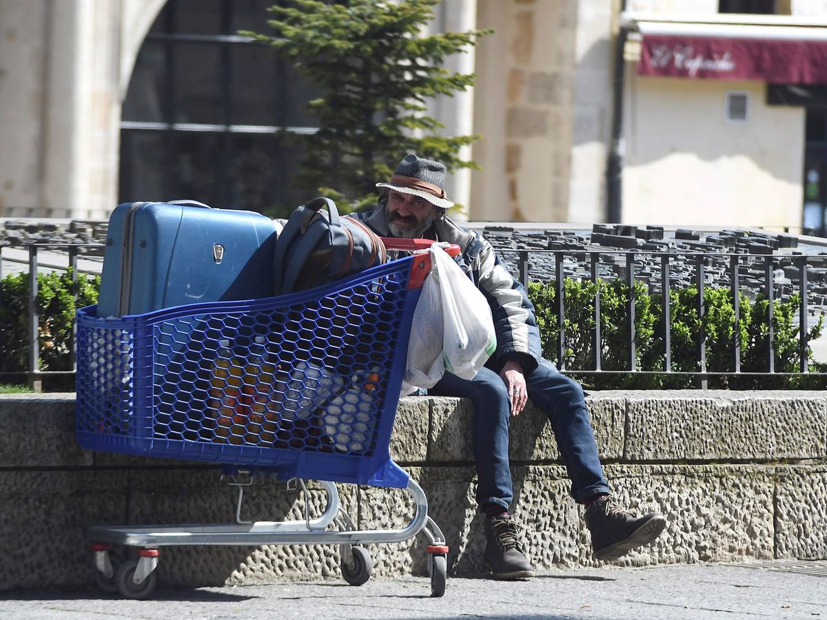 Foto: Una persona sin hogar en la plaza de San Marcelo de León, vacía este domingo en el que termina la semana hasta ahora más critica por la epidemia de coronavirus. (EFE)