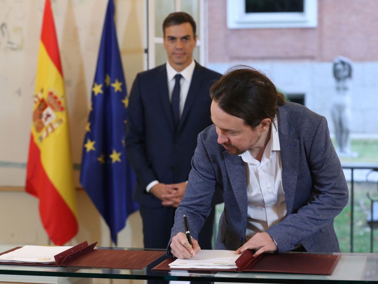 El líder de Unidos Podemos, Pablo Iglesias, firma el acuerdo sellado con el PSOE de Pedro Sánchez. (EFE)