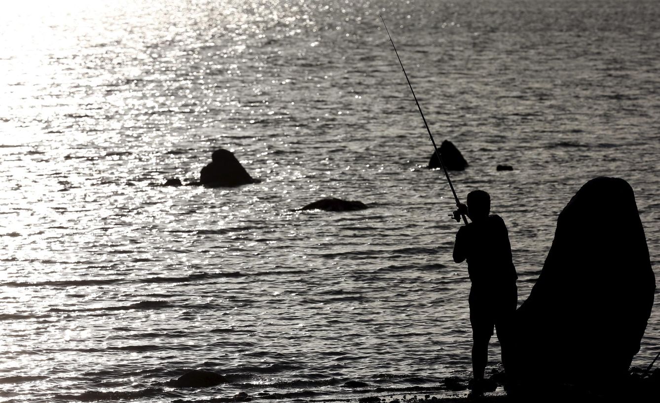 Un hombre pesca en el embalse de Valmayor, pegado a Colmenarejo. (Reuters)