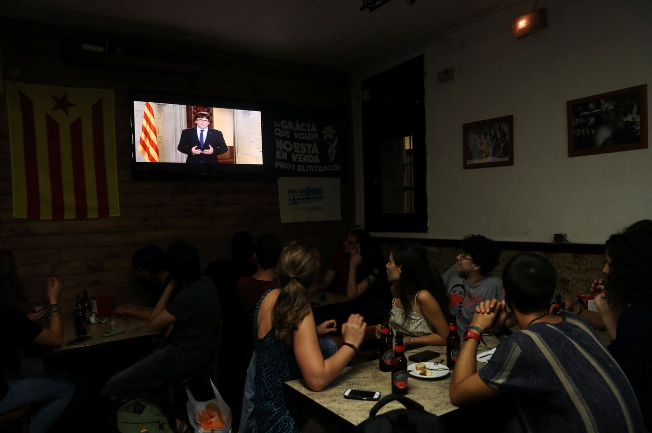 Un grupo de gente atiende en un bar al discurso del presidente de la Generalitat, Carles Puigdemont. (Reuters)