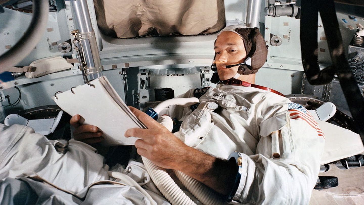 Michael Collins leyendo un manual o pensando en qué pasará si se queda tirado en órbita lunar para siempre