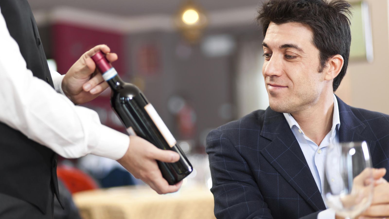Foto: Un camarero muestra un vino al cliente. (iStock)