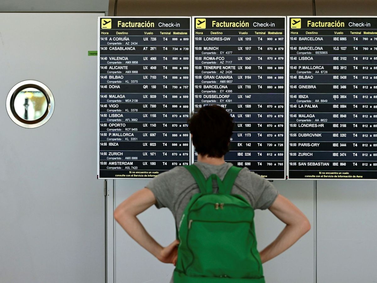 Foto: Un pasajero comprueba un panel de información sobre vuelos en la terminal 4 del aeropuerto Adolfo Suárez-Barajas en Madrid. (EFE)