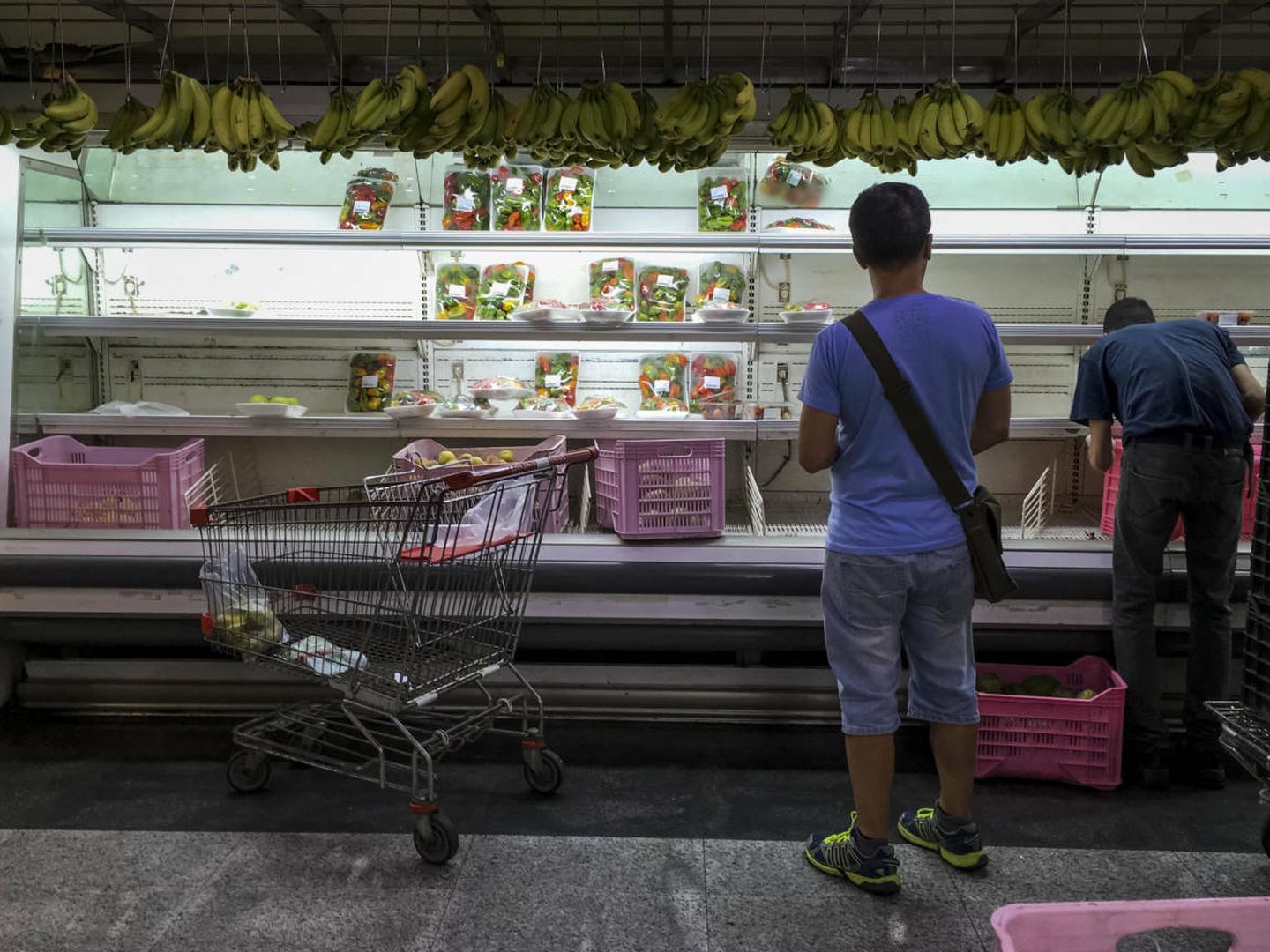Clientes buscan alimentos en un supermercado con estanterías parcialmente vacías, con vistas al parón de 48 horas convocado por la oposición a partir del miércoles. (EFE)