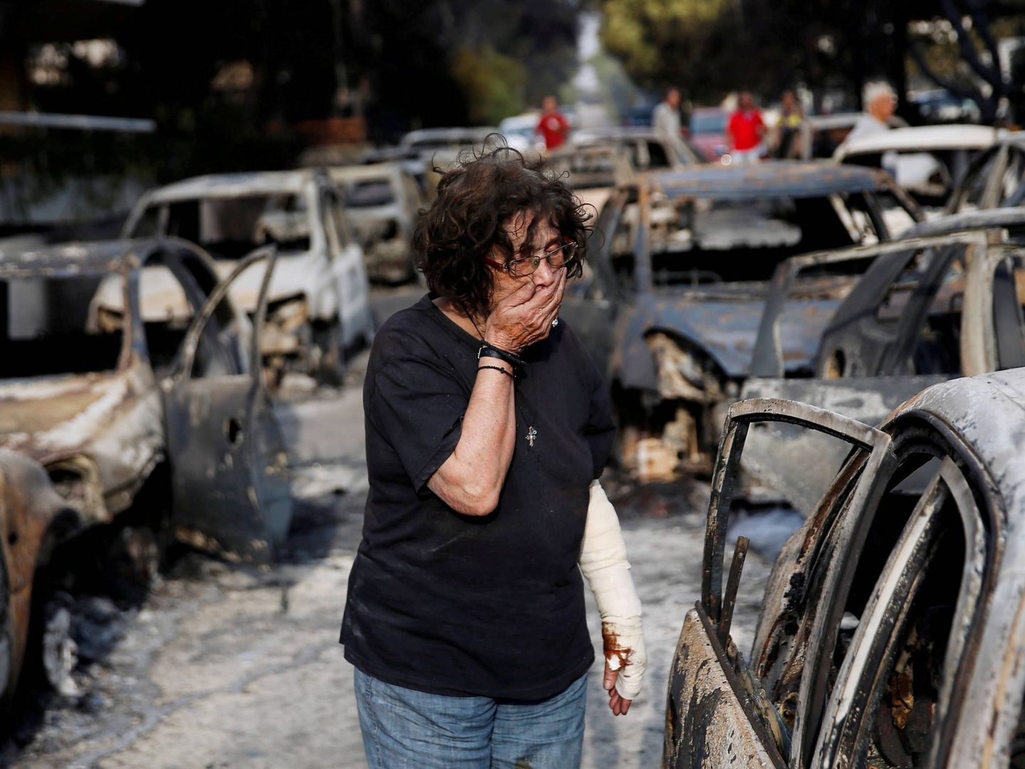 Una mujer mientras intenta encontrar a su mascota tras los incendios en el pueblo de Mati, cerca de Atenas. (Reuters)