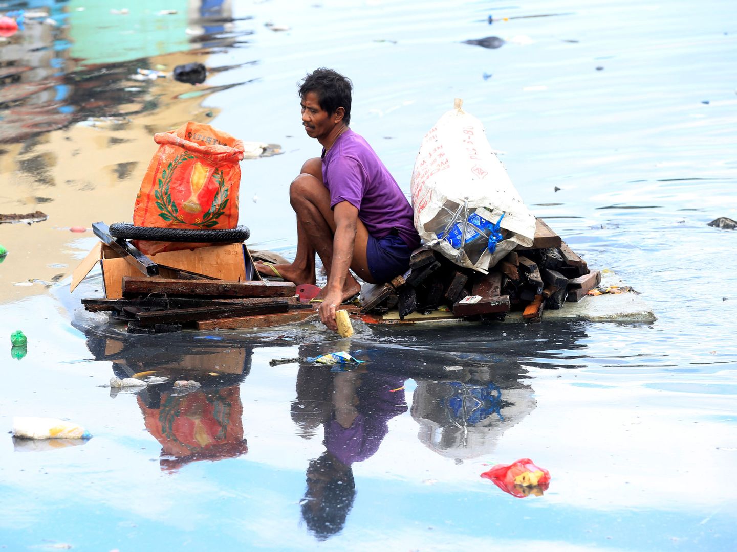Un hombre recoge basura del río Pasig en Manila, en diciembre de 2016. (Reuters)
