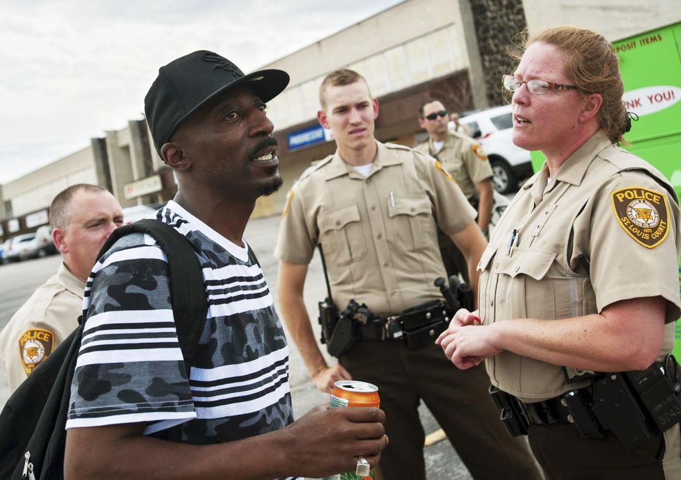 Foto: Agentes de policía de Ferguson discuten con un manifestante.
