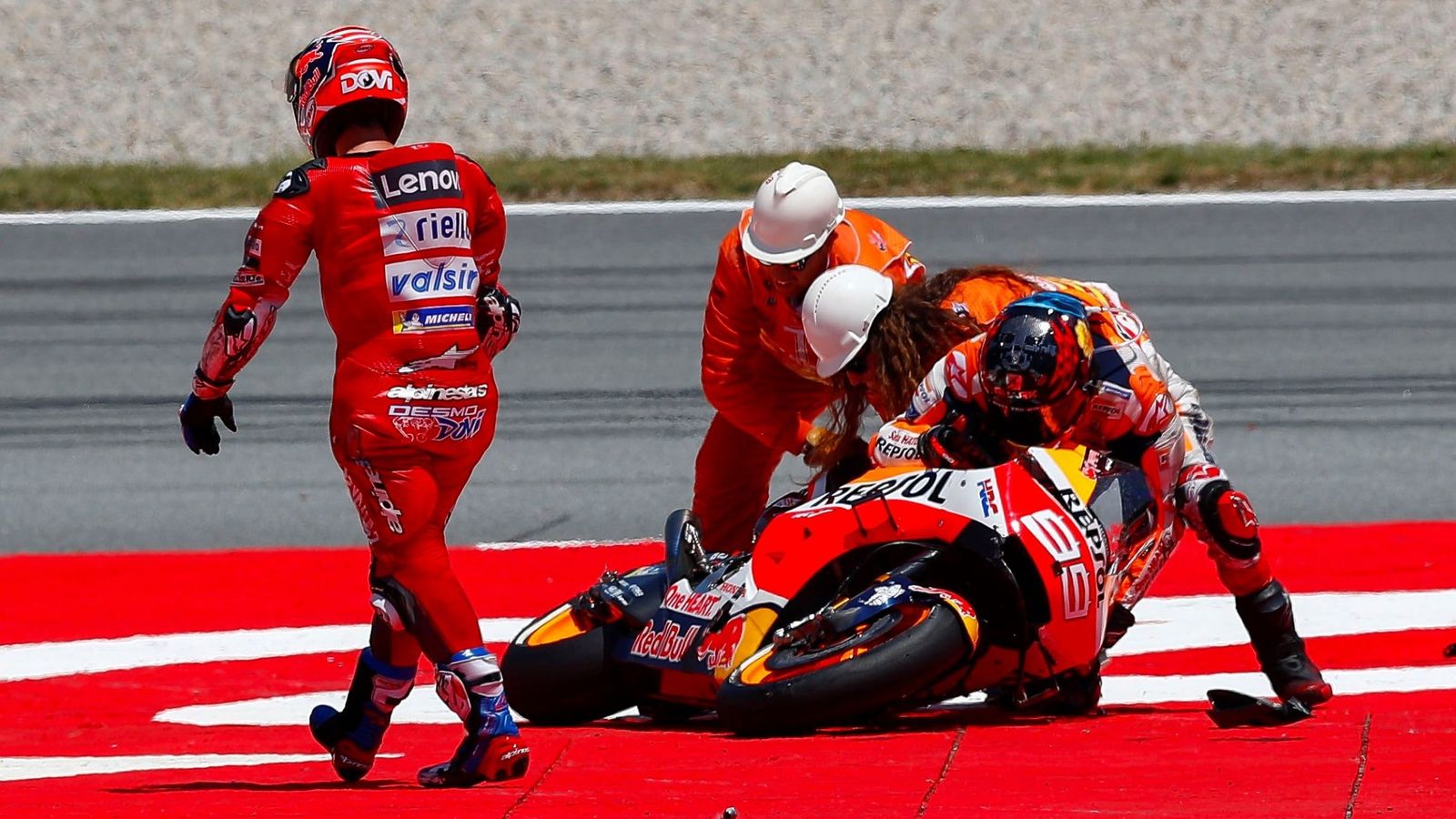 Foto: Jorge Lorenzo intenta levantar su moto frente a Andrea Dovizioso. (EFE)