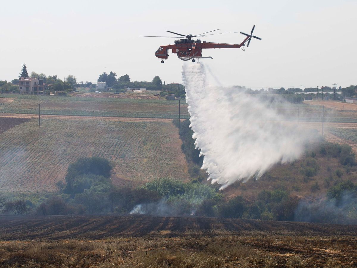 Foto: Helicóptero intentando apagar un incendio forestal en imagen de archivo. (EFE/Achilleas Chiras)  