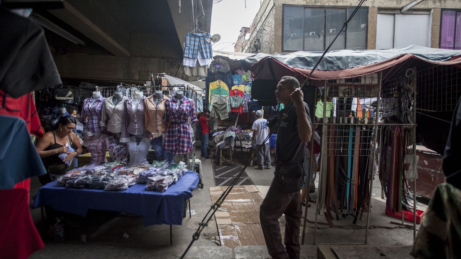 Foto: Un vendedor espera la llegada de los primeros clientes a un mercado popular en Caracas. (EFE)
