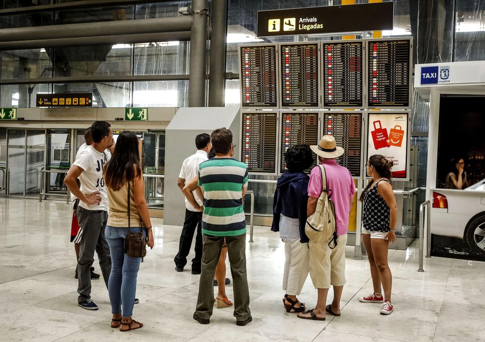 Foto: Varias personas observa uno de los paneles de información en el aeropuerto Adolfo Suárez Madrid-Barajas. (EFE)