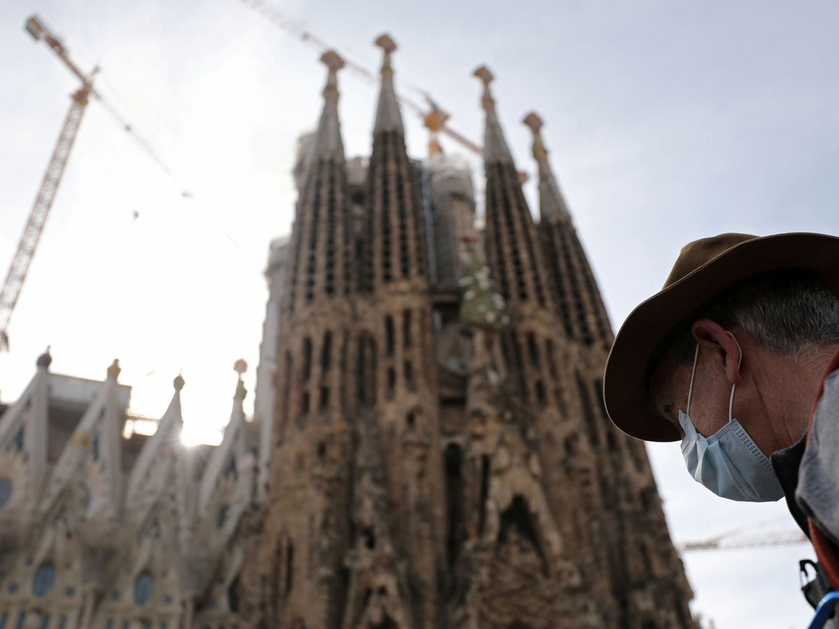 Foto: Una persona con mascarilla pasa ante la Sagrada Familia, en Barcelona. (Reuters)