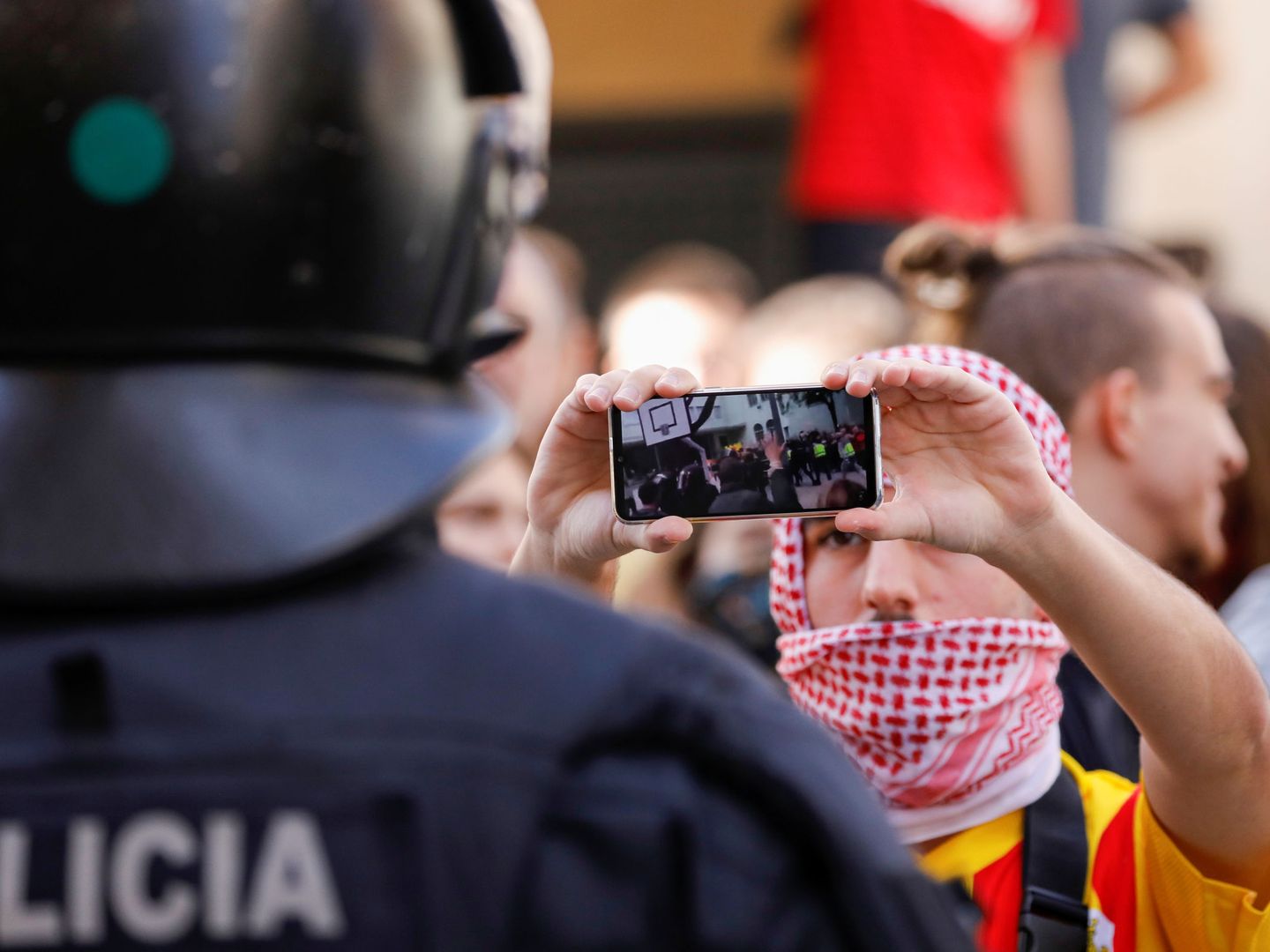 Un manifestante le enseñaa un video de las protestas a un policía apostado frente al centro Saudade, donde se encuentra Albert Rivera.  (Reuters)