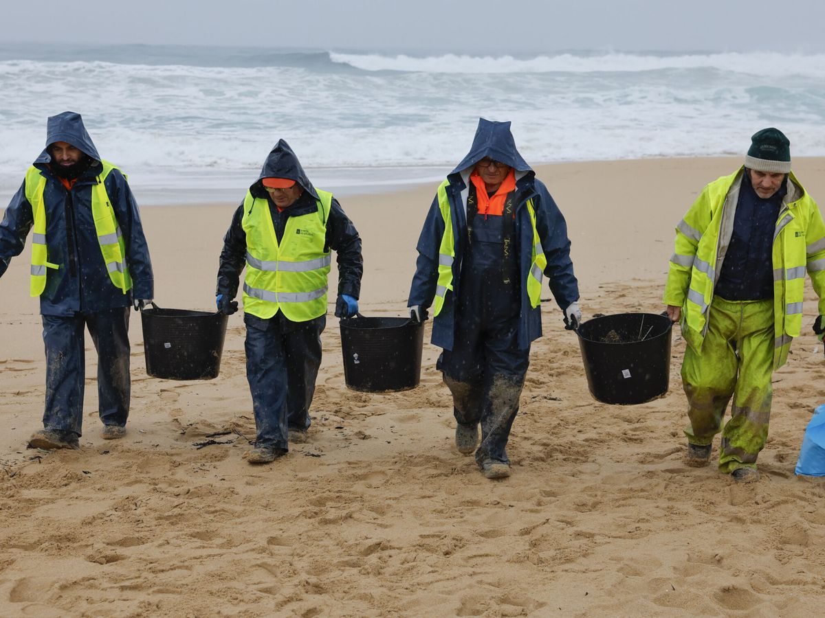 Foto: Operarios de empresas contratadas por la Xunta retiran los 'pellets' en la playa de O Vilar, en A Coruña. (EFE/Lavandeira Jr.)