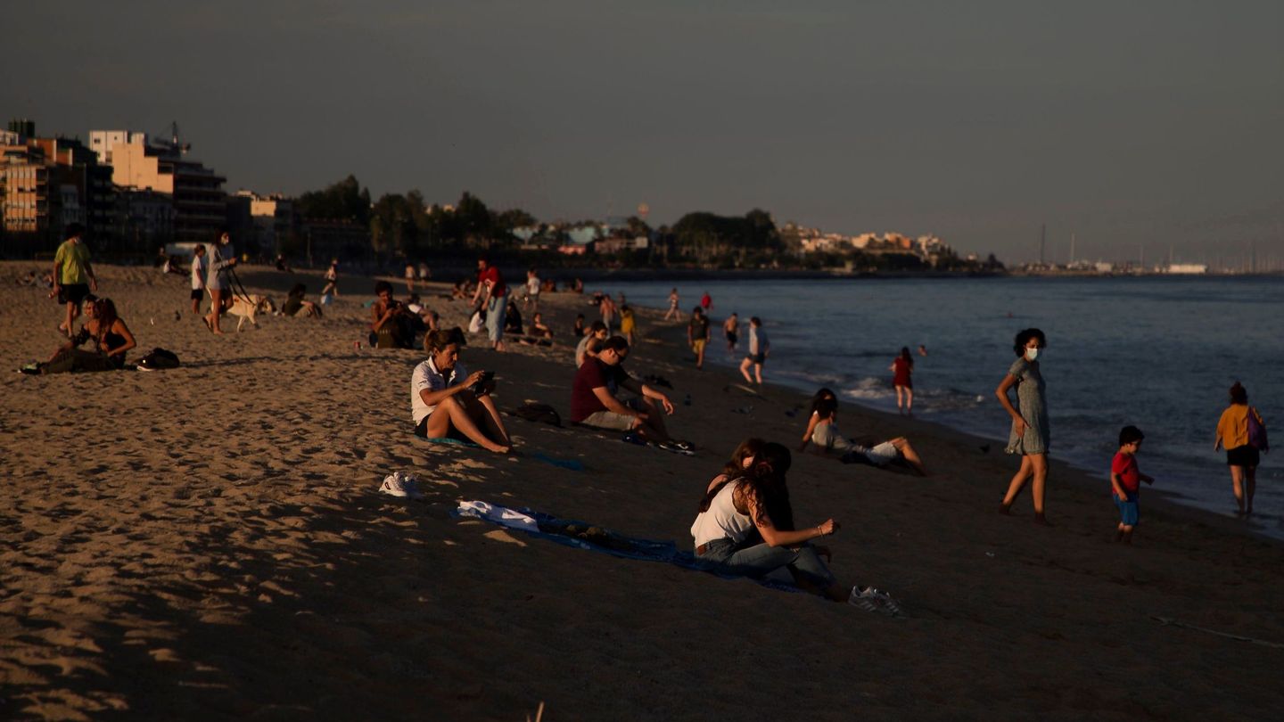 Varias personas pasean y hacen deporte por la playa y espigón del puerto de la población de El Masnou (Barcelona), este 22 de mayo. (EFE)
