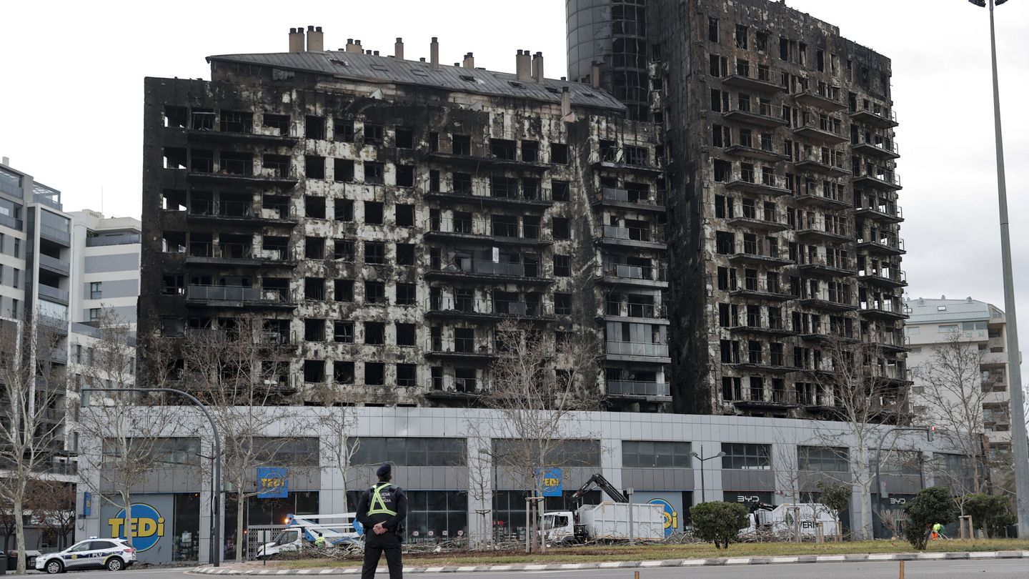 Vista del edificio incendiado custodiado por un agente. (EFE/Manuel Bruque)