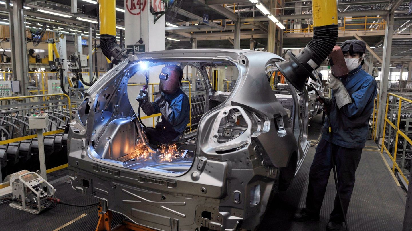 Empleados trabajan en la producción en cadena de automóviles. (EFE)