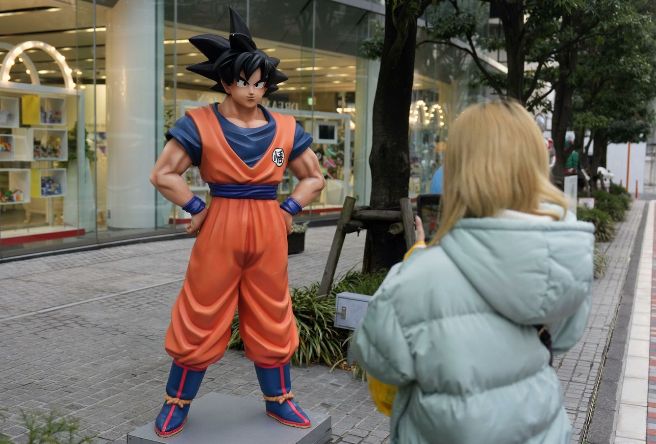 Un turista toma fotos de una estatua de Son Goku. (EFE/EPA/Franck Robichon)