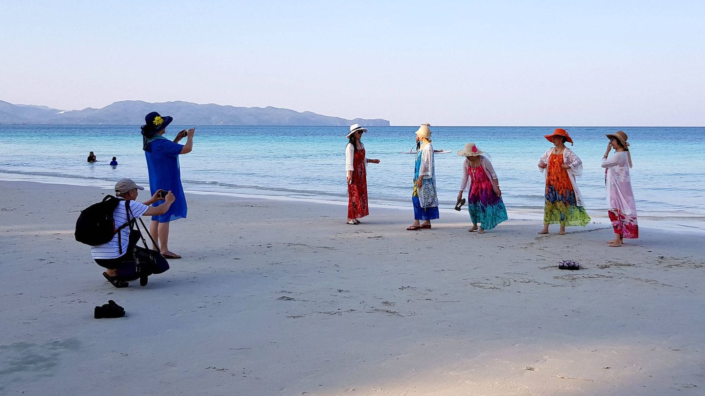 Turistas chinos se hacen fotos en la playa de Boracay al amanecer. (L. Garrido-Julve)