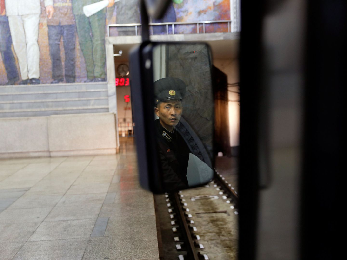 Un trabajador del metro de Pyongyang visto por el espejo, en abril de 2017. (Reuters)