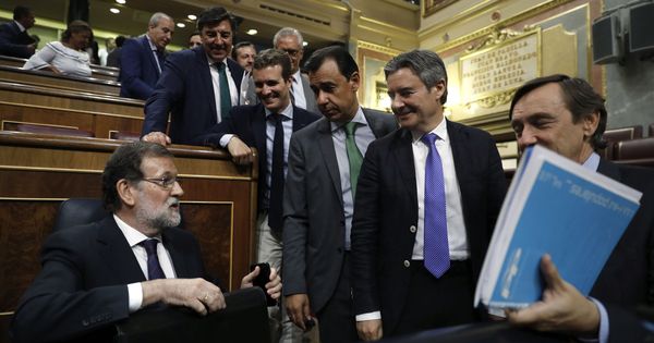 Foto: El presidente del Gobierno, Mariano Rajoy, conversa con diputados de su grupo en el Congreso. (EFE)