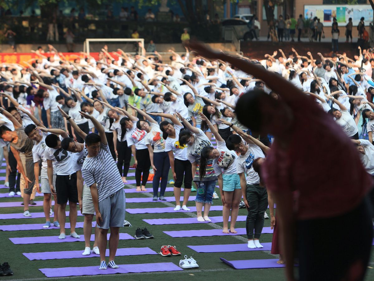Foto: Alumnos chinos haciendo yoga antes de realizar el 'gaokao', la selectividad china. (Reuters/Stringer)