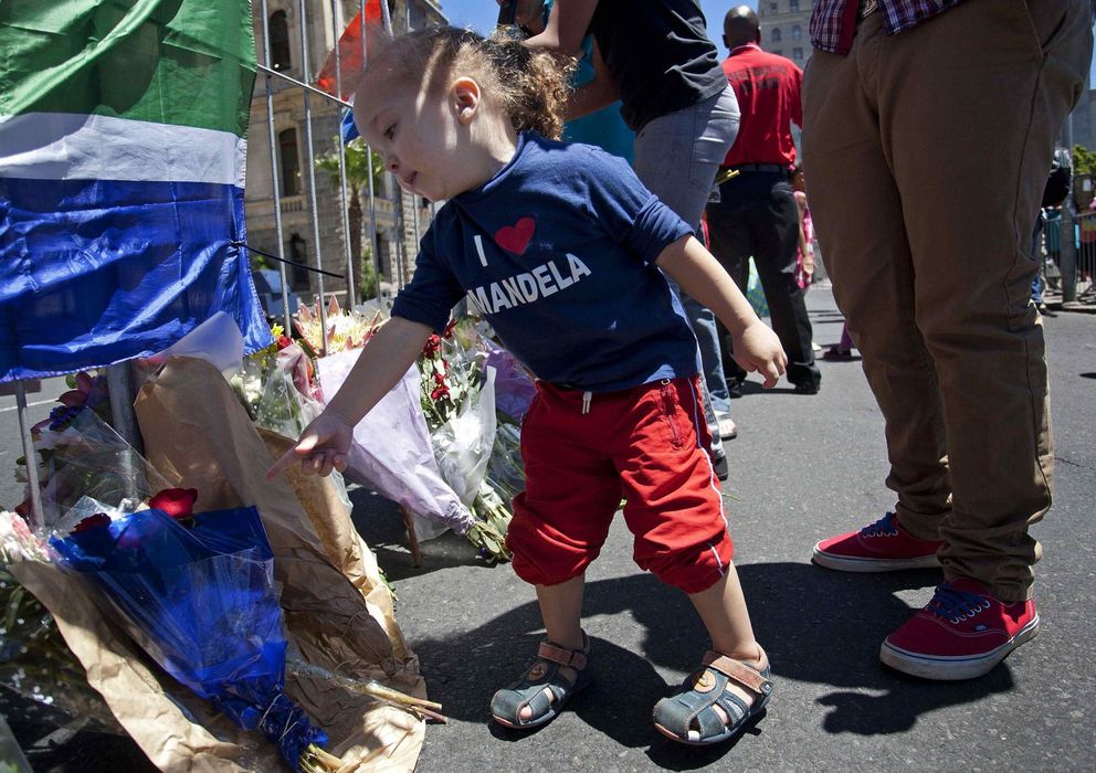 Foto: Una niña con una camiseta con el rostro de Mandela deposita flores en el Ayuntamiento de Ciudad del Cabo (Reuters).