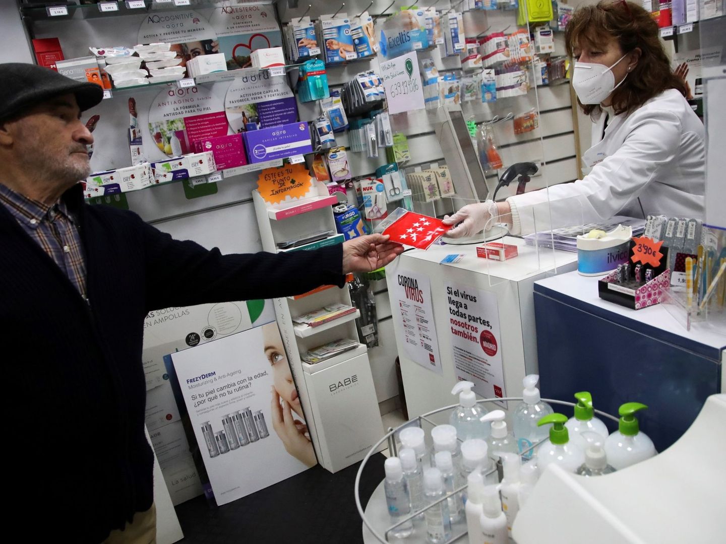 Un hombre recoge en una farmacia de Madrid una de las mascarillas que entregó la CAM. (EFE)