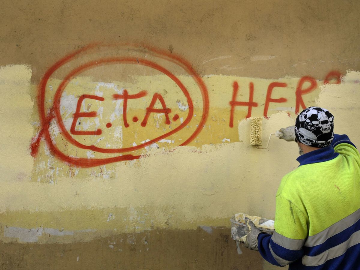 Foto: Un trabajador municipal borra una pintada a favor de ETA en Guernica. (Reuters)