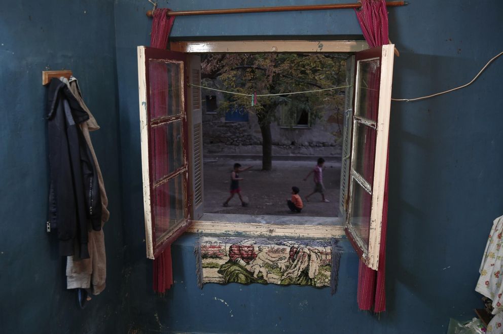Niños juegan ante el complejo de viviendas Prosfygika, en Atenas (Reuters).