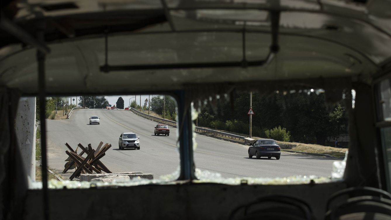 Foto: Automóviles pasan junto a un autobús destruido a un costado de la carretera que conduce a Dnipro (Ucrania).  (EFE/Orlando Barría)