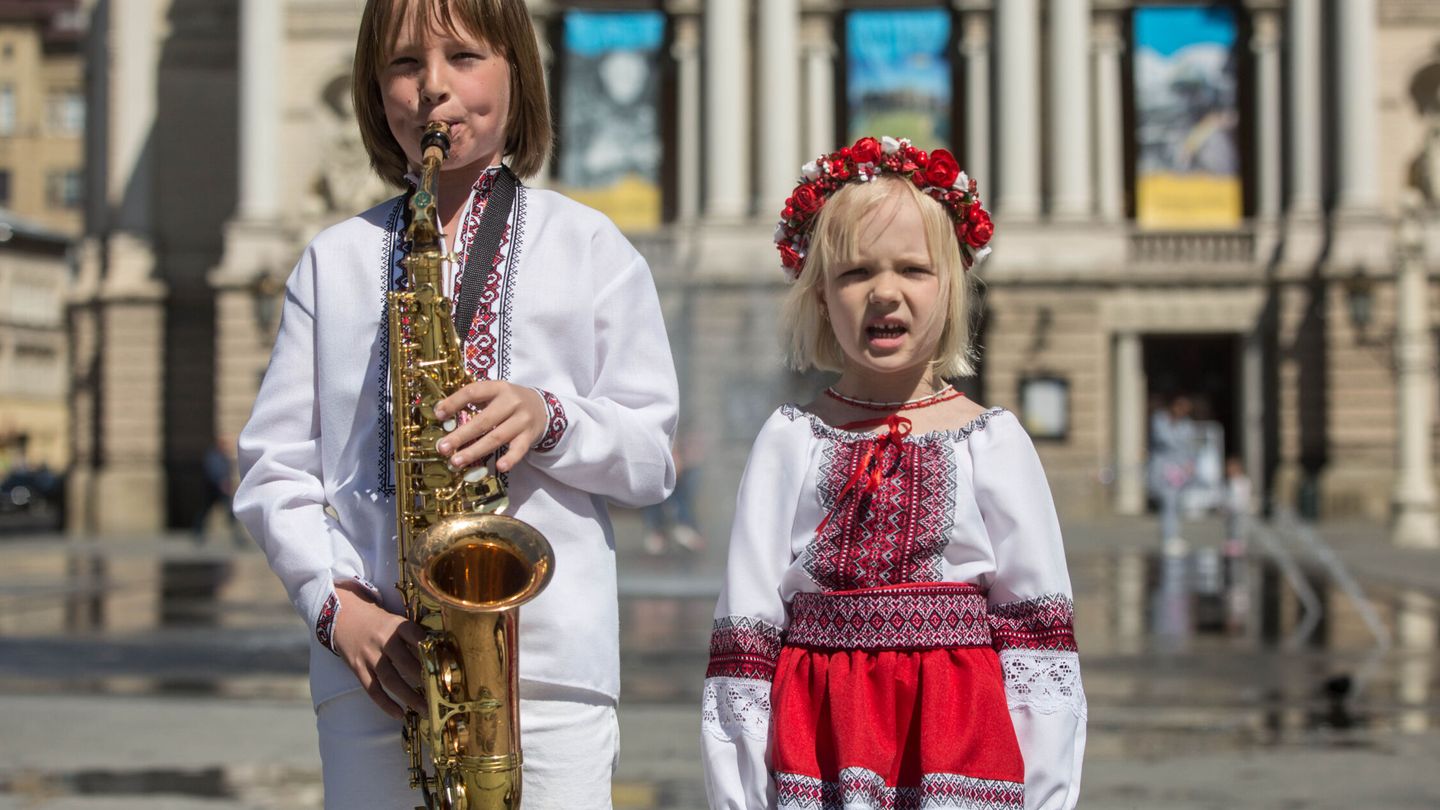 Dos niños interpretan el himno de Ucrania en Leópolis mientras utilizan la 'Vyshyvanka'. (EFE/Esteban Biba)