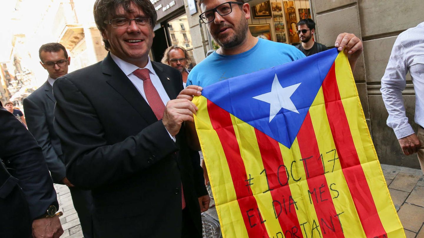 Carles Puigdemont, con un simpatizante de la consulta. (Reuters)