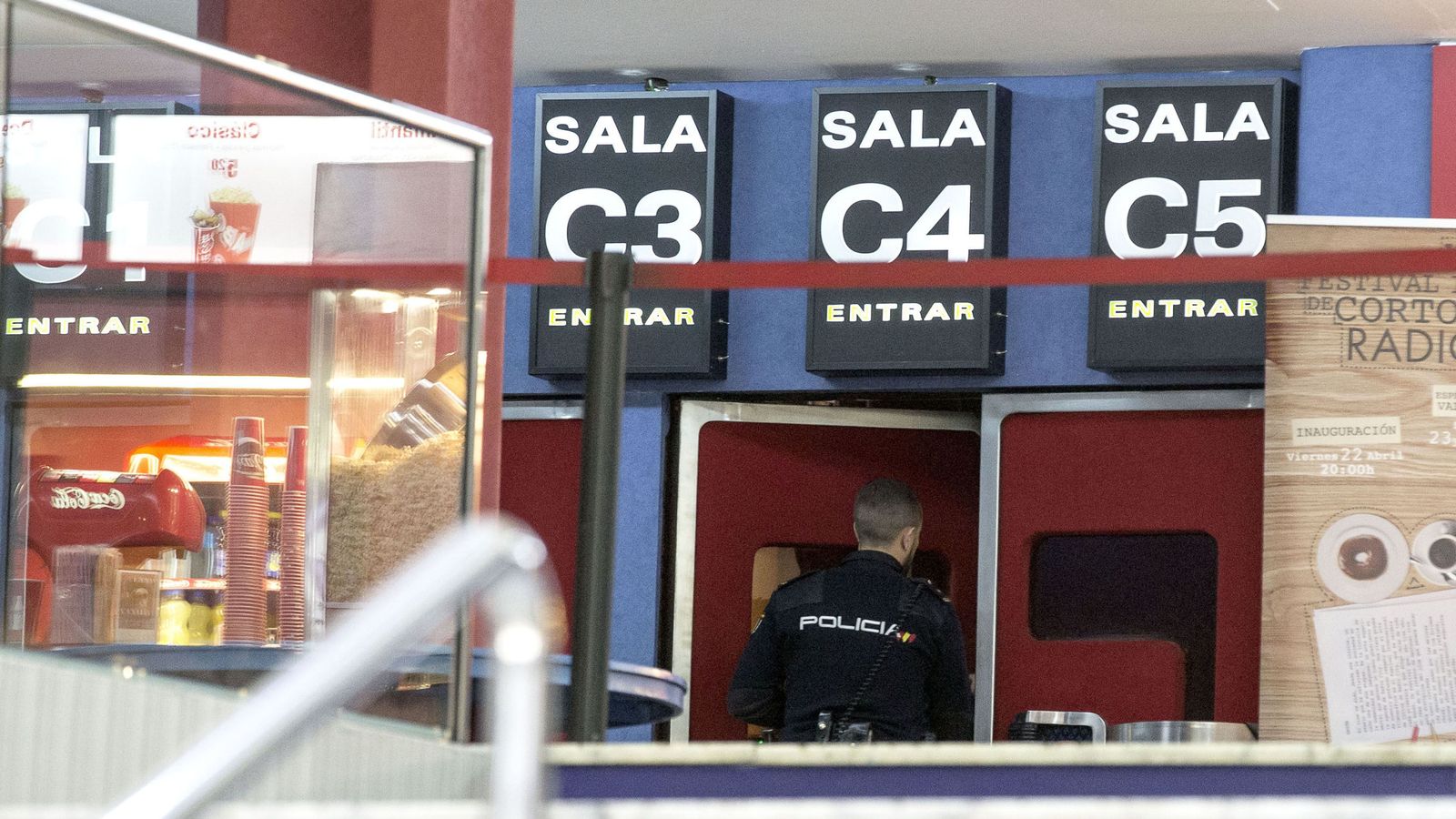 Foto: Un agente de policía entra en una de las salas del céntrico cine de Valencia donde ha aparecido el cuerpo sin vida de una mujer. (EFE)