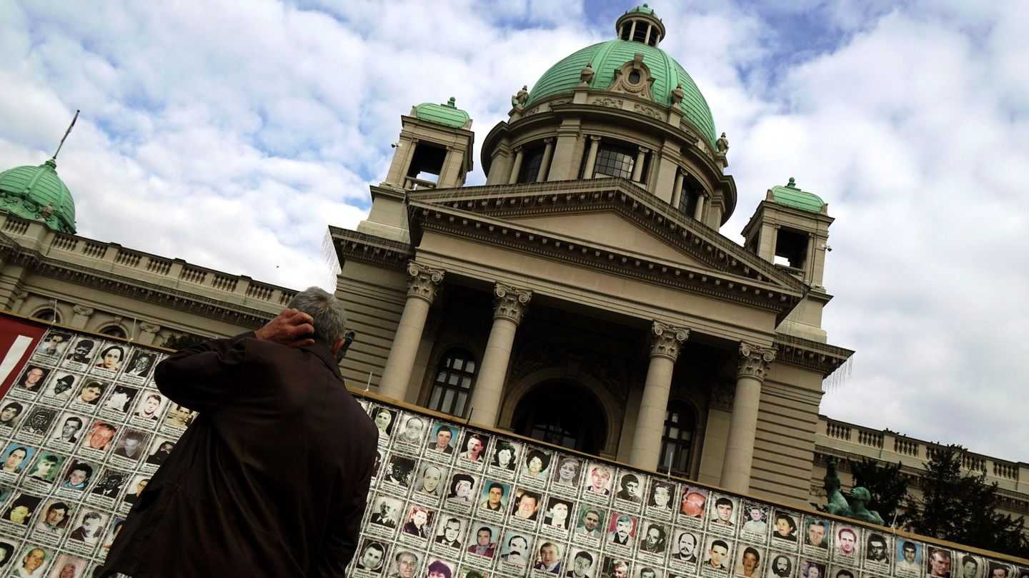 Un hombre observa fotografías de los desaparecidos durante la guerra de Kosovo expuestas ante el Parlamento serbio en Belgrado, el 16 de noviembre de 2018. (EFE)