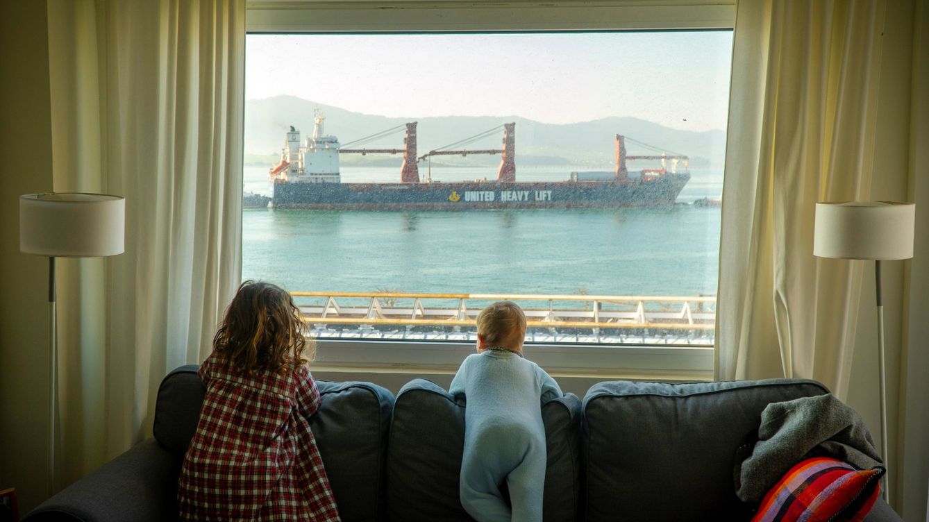 Foto: Dos niñas observan desde casa la entrada de barcos mercantes en la bahía de Santander a principios de marzo. (EFE)