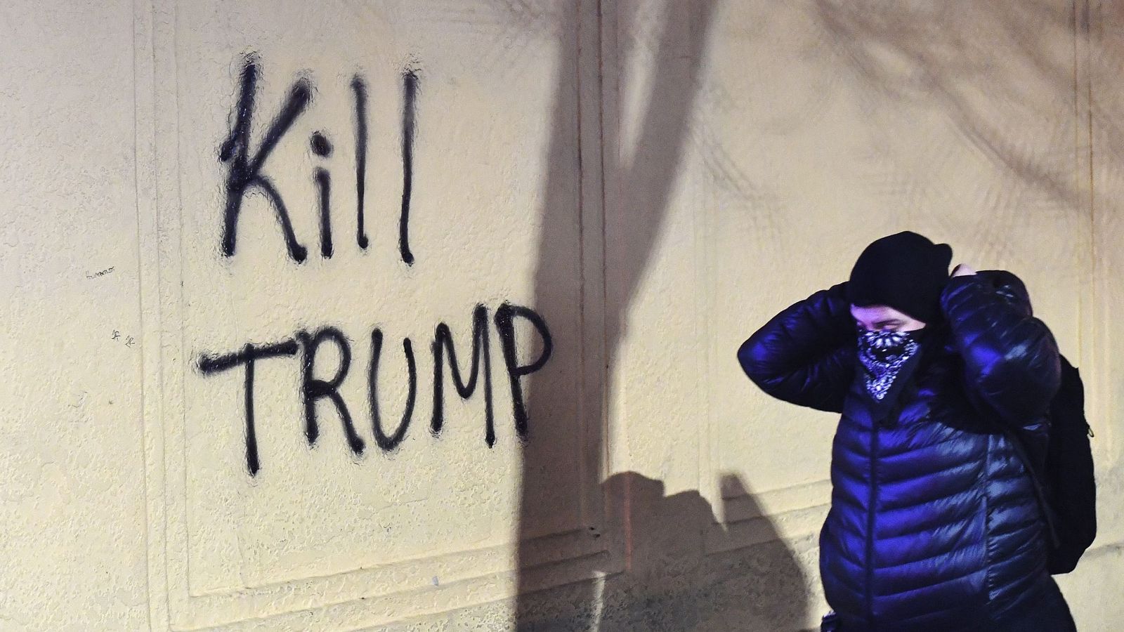Foto: Una mujer camina junto a una pintada que reza 'Matad a Trump'. (EFE)