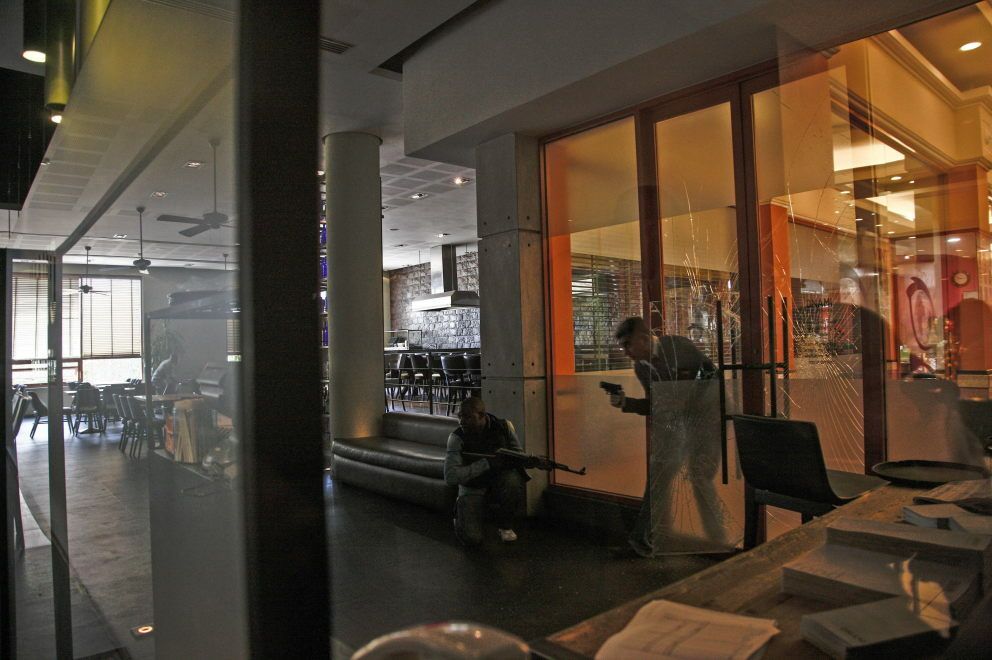Hombres armados revisan una cafetería en el centro comercial. (EFE)