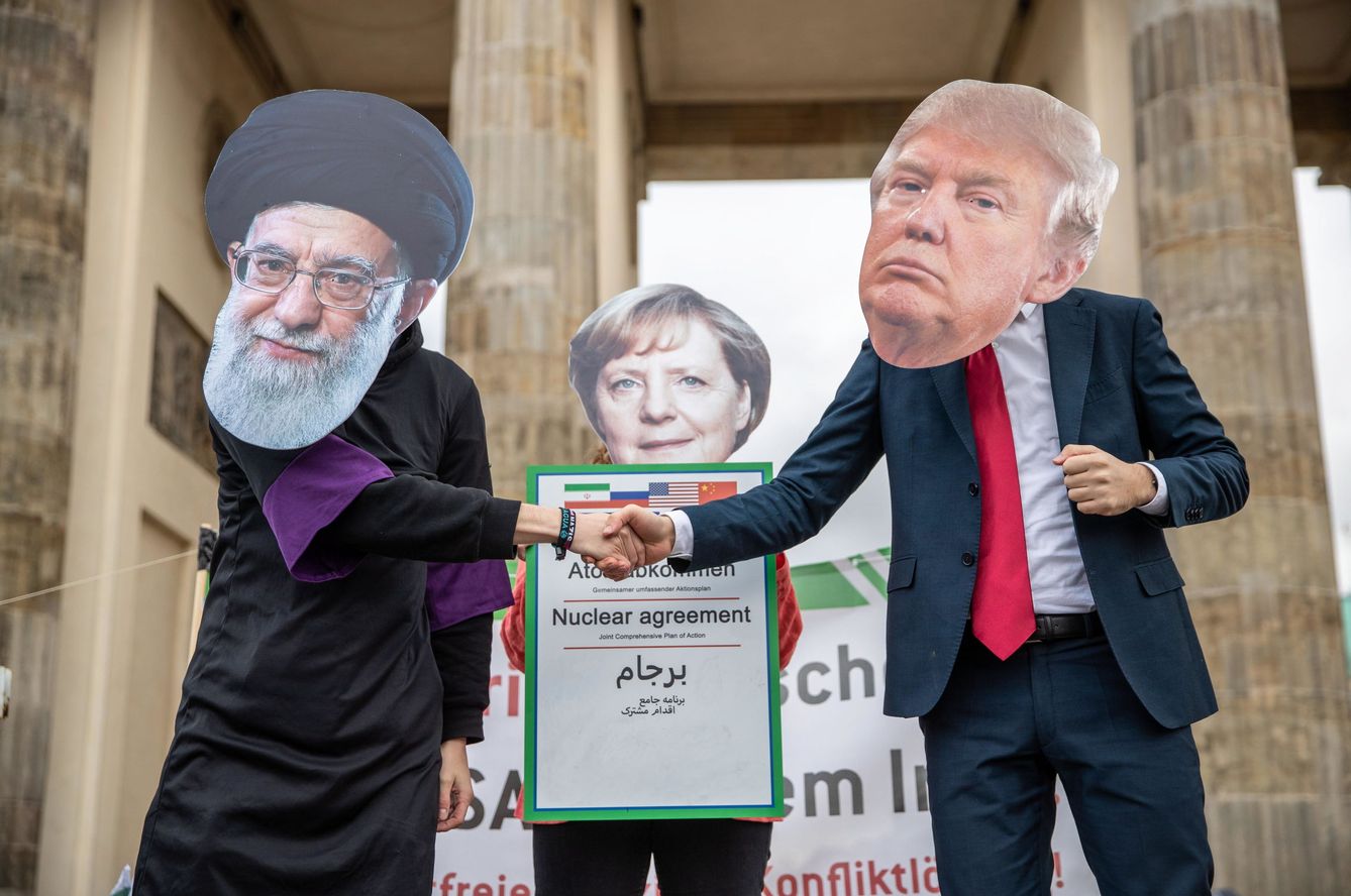 Activistas disfrazados de Trump, Merkel y Ali Khamenei frente a la Puerta de Brandenburgo en Berlín. (EFE)