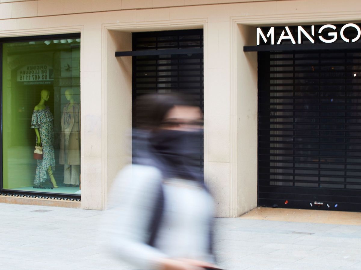 Foto: Una mujer pasa ante una tienda cerrada de Mango, en Barcelona. (EFE)
