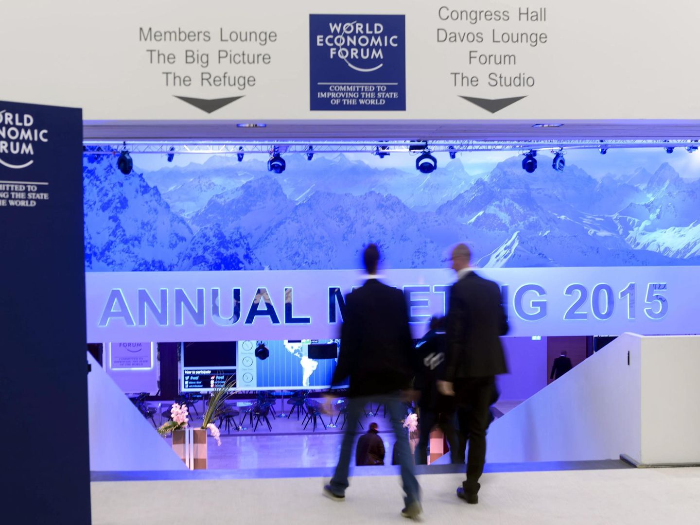 Dos personas entran en el congress hall en la víspera del Foro Económico Mundial (Efe).