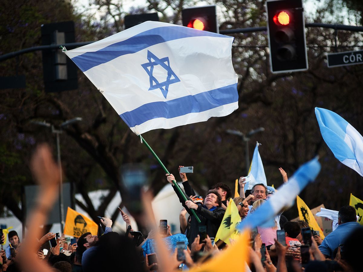 Foto: Javier Milei ondea una bandera israelí durante un acto de campaña. (EFE/Franco Trovato)