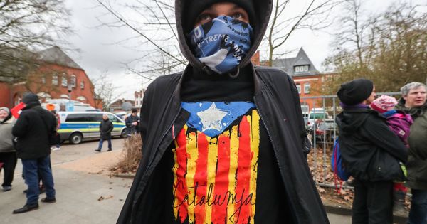 Foto: Un joven que lleva una camiseta con una estelada, ante la cárcel de Neumünster, este lunes. (EFE)