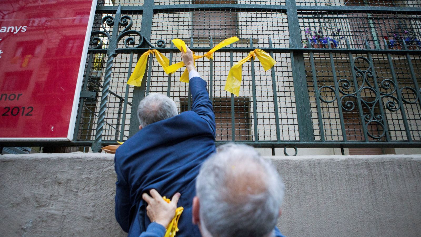 Foto: Dos de los miembros de los grupos de defensa y resistencia (GDR) —contrarios a la independencia de Cataluña— retiran los lazos amarillos previamente colocados por CDR. (EFE)